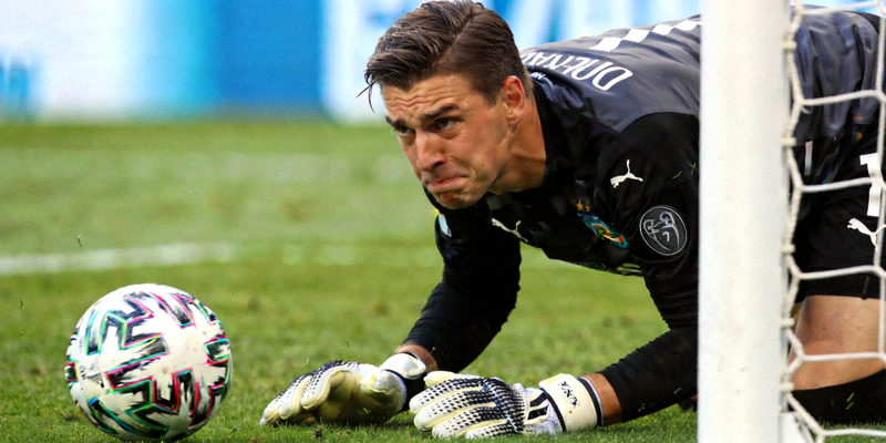 足球场上守门员扑救失误后尴尬表情特写